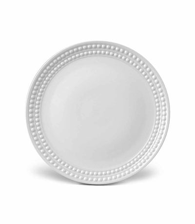 white porcelain dinner plate with rows of raised pearls around the rim